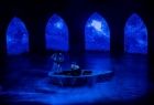 Aktorzy na scenie opery siedzą w łódce.